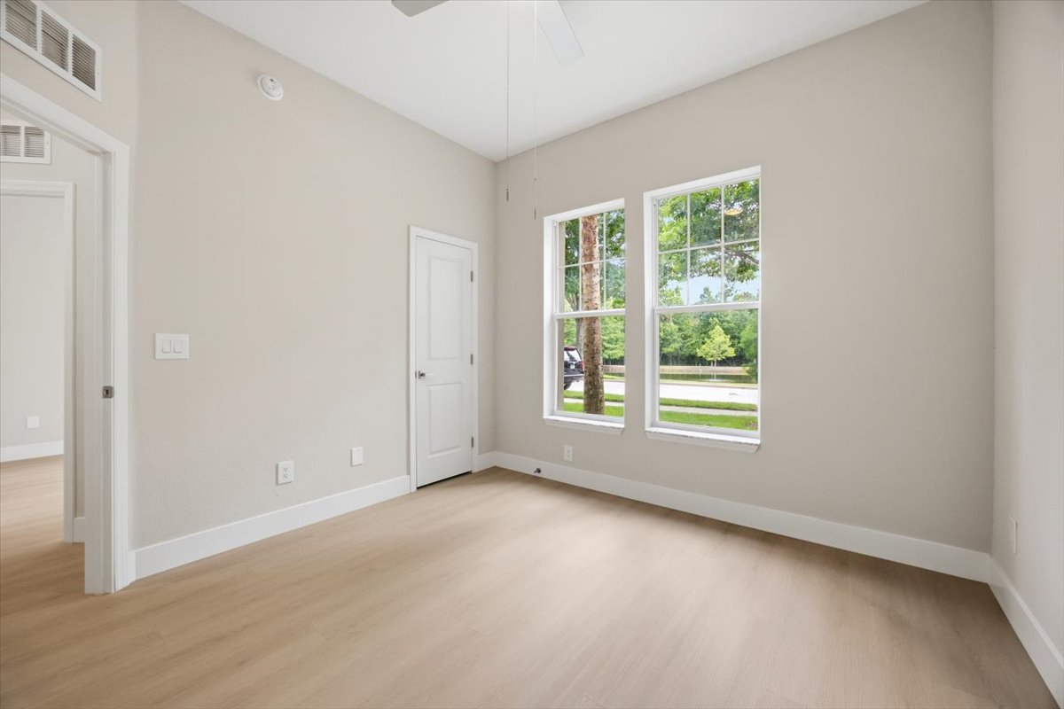 Secondary bedroom with double windows framing mature landscaping