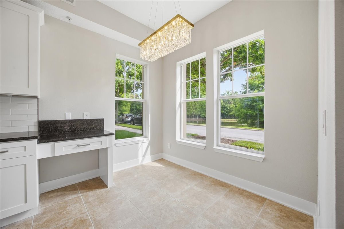 Dining nook with chandelier, granite-topped built-in, and pondside windows